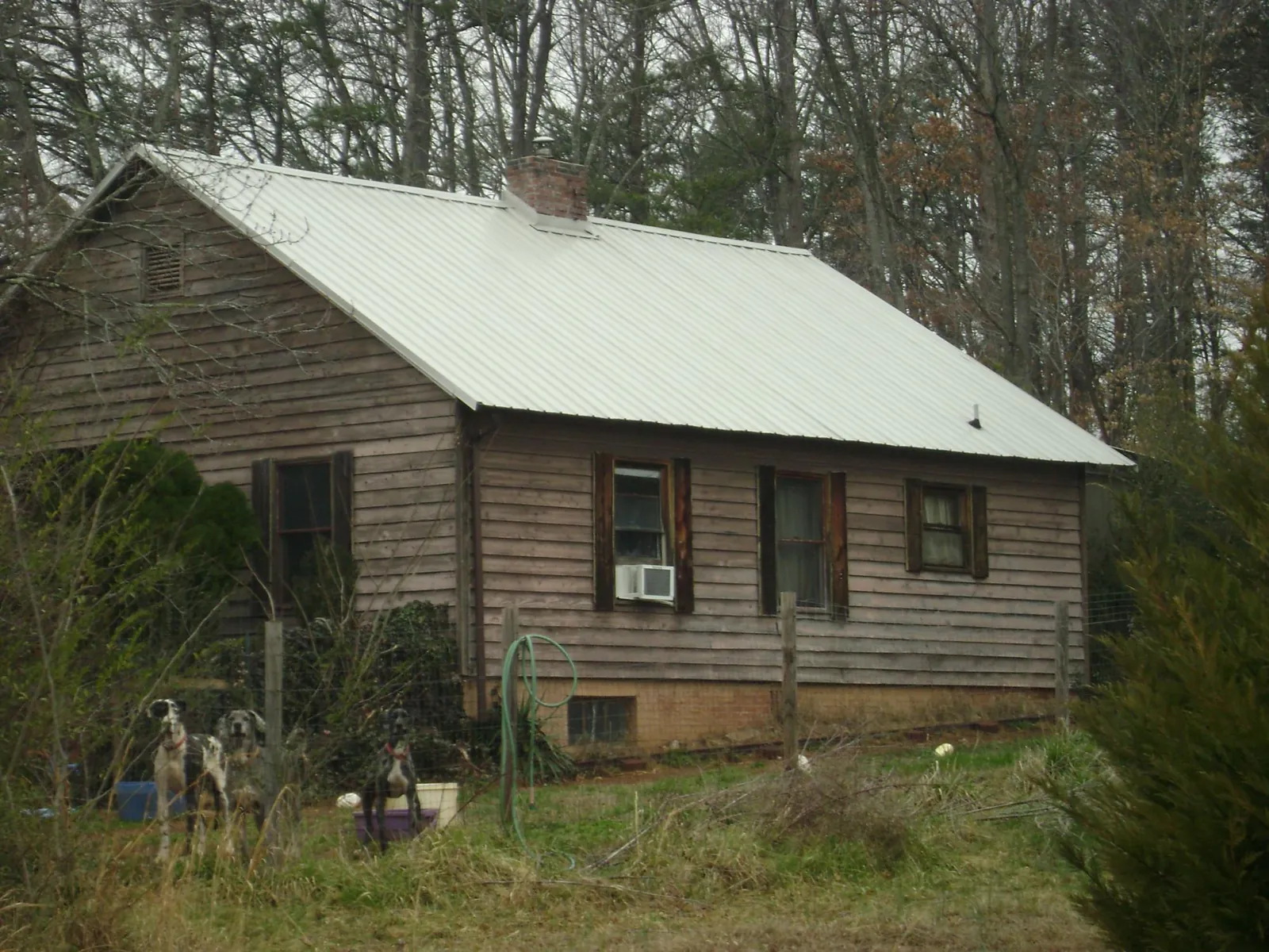 White metal roof on an old wood sided farmhouse, from a Metal Roof Installation job in Sanders